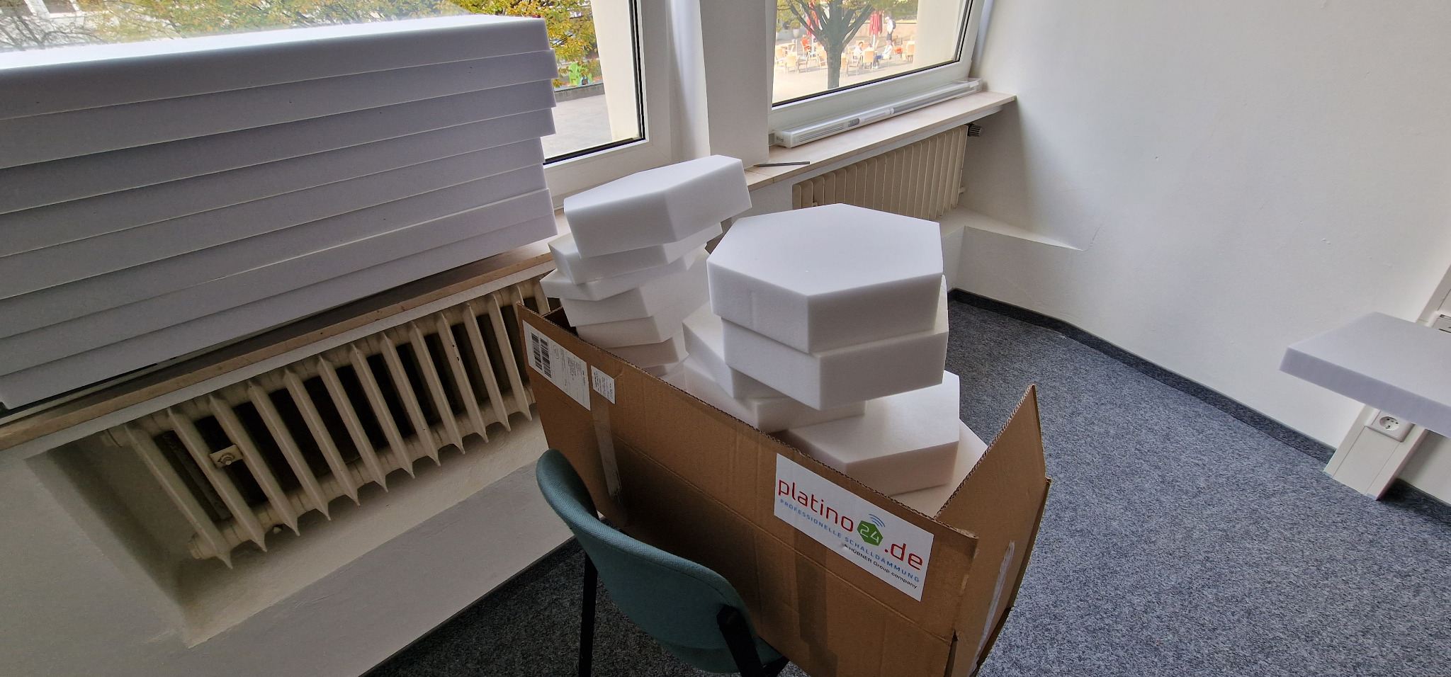 Gestapelte Akustikelemente vor der Montage im Podcast-Raum der Gläsernen Werkstatt Solingen.