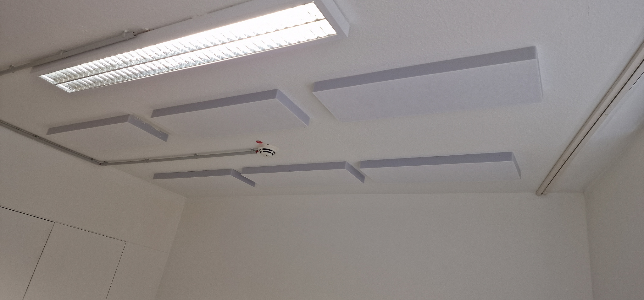 An der Decke montierte Akustikabsorber zur Verbesserung der Raumakustik des Podcaststudios in Solingen.