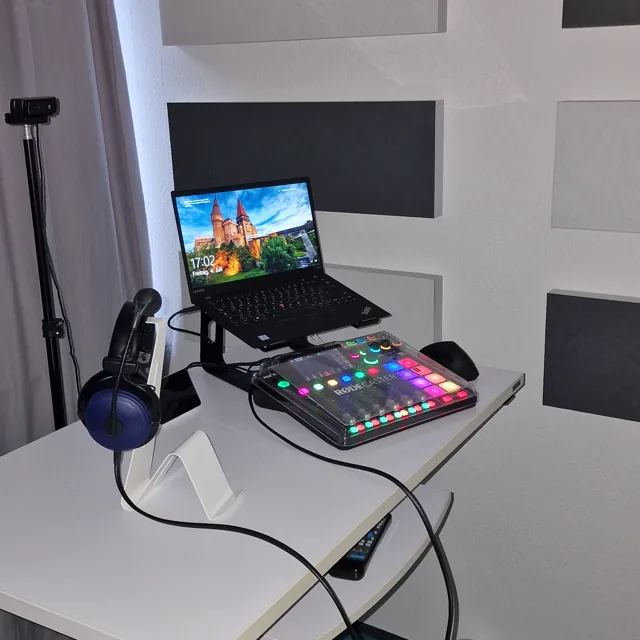 Vollständig eingerichtetes Podcaststudio mit Laptop, Rodecaster und Kopfhörern